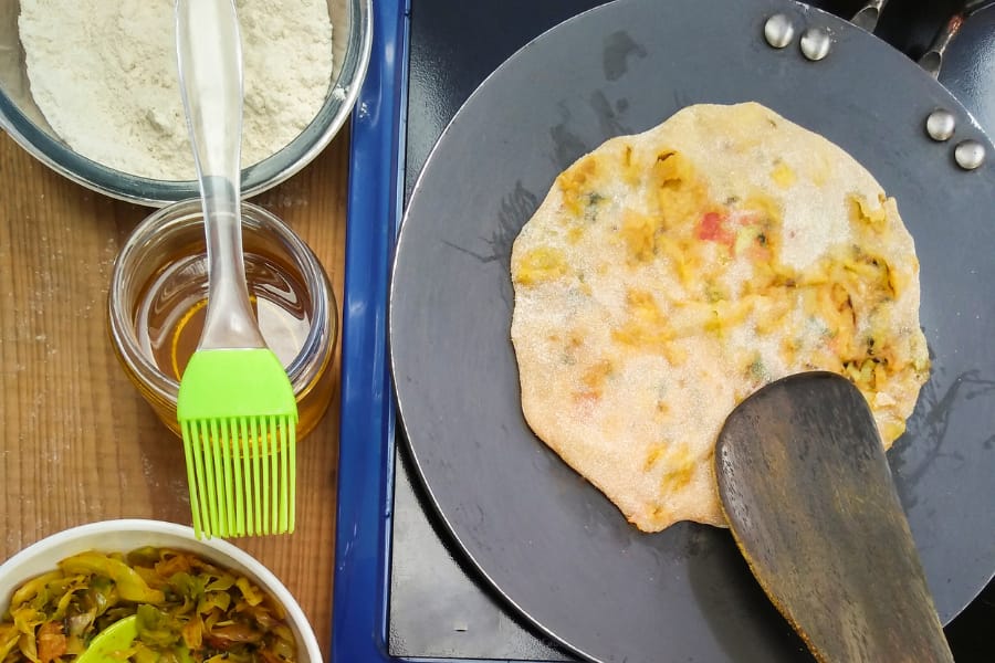 making aloo paratha in a roti tawa